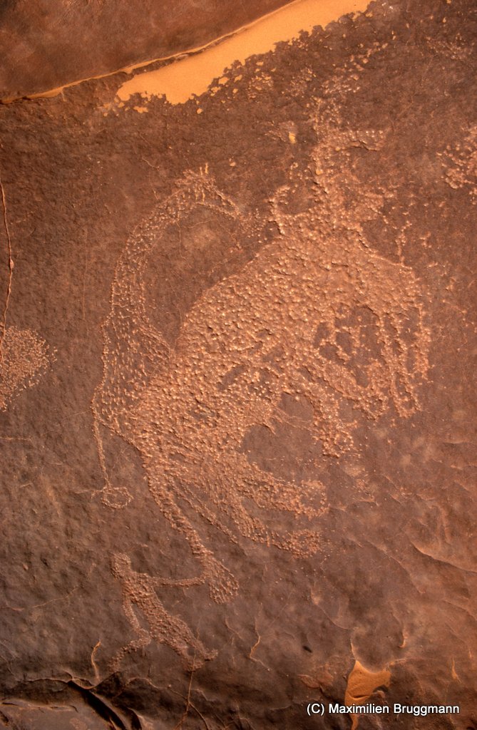 126 Enneri Blaka. Site 11. — A une girafe piquetée sont superposés deux (?) quadrupèdes non identifiés. Un homme se tient à l'arrière et touche la queue de l'un d'entre eux.